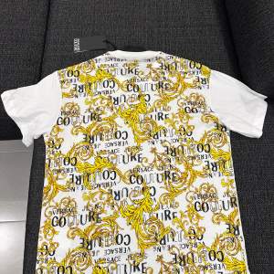 Helt ny, äkta Versace Jeans Couture T-shirt köpt från zalando.  Alla original tags sitter på.  Original pris: 1 475kr Färg: vit/ guld  Storlek: Xs  Priset går att diskutera vid snabb affär 