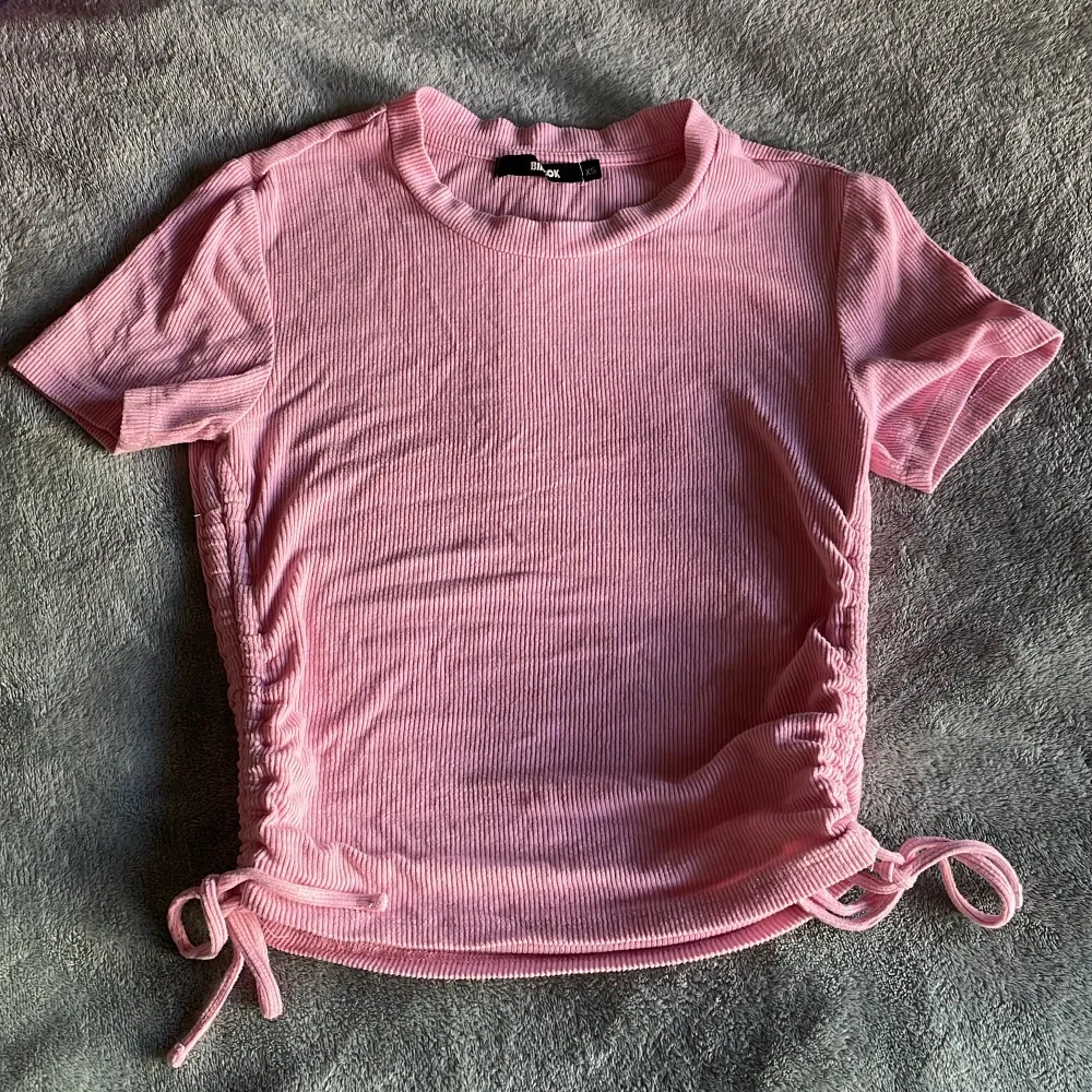 En rosa T-shirt som har knyten på sidan. Passar med mycket och har väldigt stretchigt och mjukt👍. T-shirts.