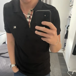 BURBERRY PIKÉ NYSKICK - Säljer denna asfeta pikéskjortan. Den är i storlek L men passar även M. Säljer eftersom jag inte använder den! Perfekt att ha under jackan nu i vinter!