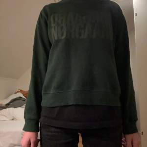 Den här Mads nørgaard tröja är en superfin mörkgrön tröja i bra skick, texten har fadeats bort lite grann.
