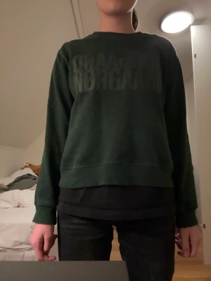 Mads noørgaard tröja  - Den här Mads nørgaard tröja är en superfin mörkgrön tröja i bra skick, texten har fadeats bort lite grann.
