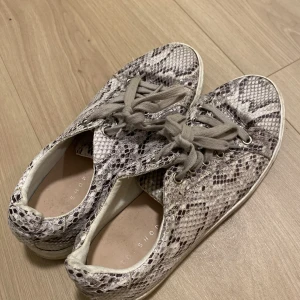Skor - Sneakers i orm imitation från Topshop! Skorna är i storlek 38. Skorna är använda några gånger men är i fint skick☺️ 100kr+frakt