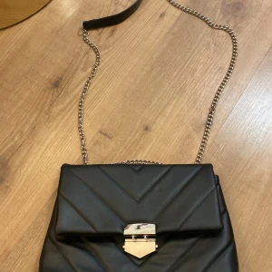 Svart väska  - Säljer denna svart väska från Glitter eftersom den aldrig kommer till användning. Köpte för 250kr. 