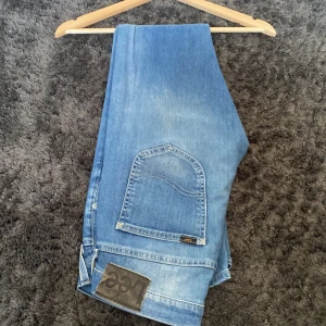 Lee jeans - Ljusblåa Lee jeans i regularfit som jag aldrig använt. Lee loggan på höger bakficka.  Storlek W30 L32 