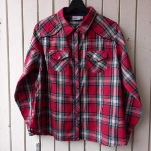 Comfy flannel shirt, fitted for its size.  100% cotton.  Sleeves can be cuffed and secured with a strap and a button.   Length 67 cm. Shoulder width 39 cm. Sleeve length measured from the underarm 45 cm. Sleeve length (cuffed) 25 cm. Underarm width 54 cm.