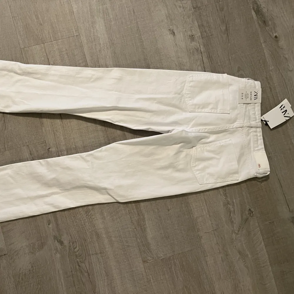 Säljer dessa oanvända vita jeans köpta från zara. Högmidjade. Slit nere på benen. Stl 36 . Jeans & Byxor.