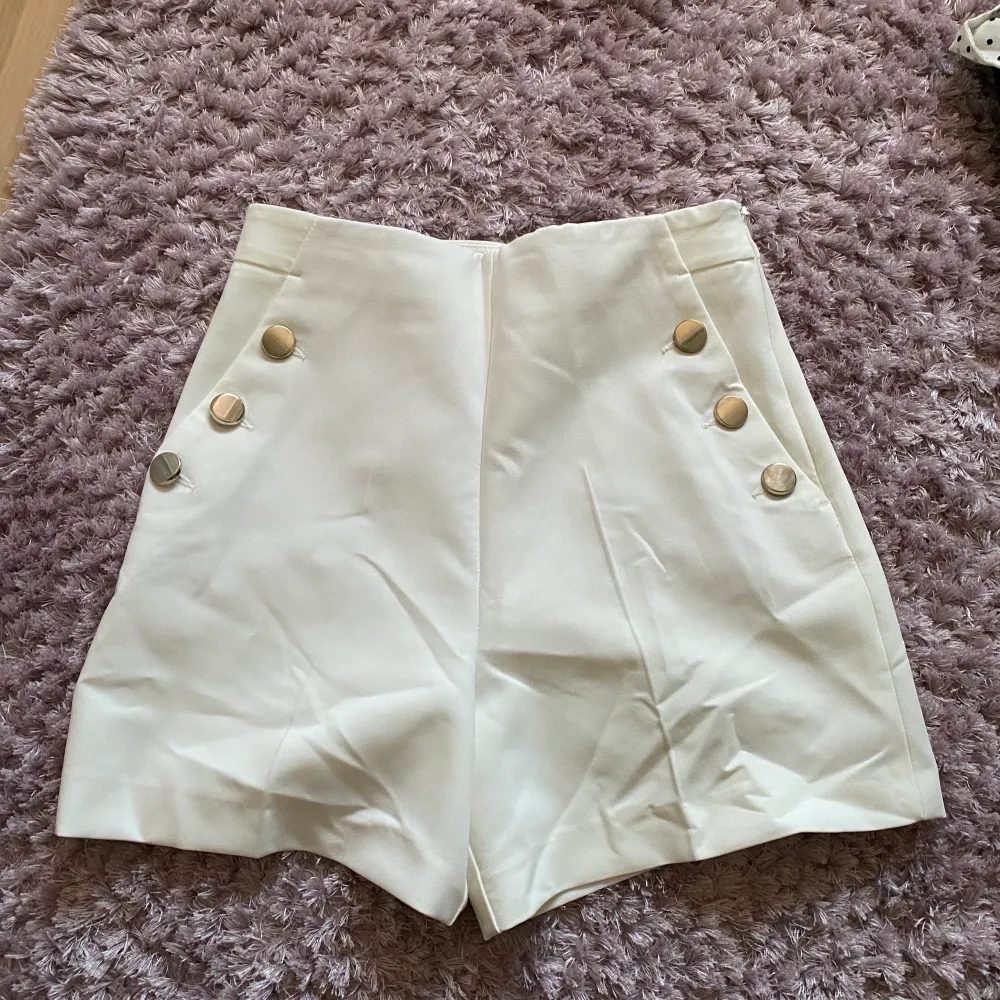 Vita kostym shorts från zara i storlek s med guld detaljer.. Shorts.