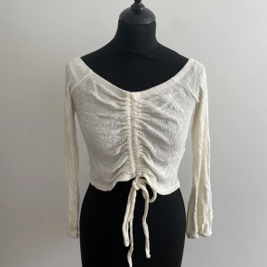 Croptop  - Offshoulder croptop med dragsnöre som kan justera längden. Cremevit Strl S