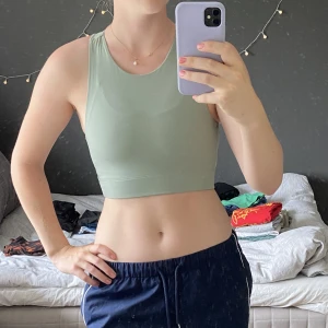 Grönt Linne - Ljusgrönt, tight och kroppat linne i matt träningsmaterial. Älskar men är tyvärr för liten för mig så endast använd en gång. Köpt på Gina på rea för 70 kr. Vet ej org pris