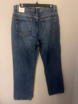 Ett par helt nya jeans med prislapp kvar  Jeans med knappar 