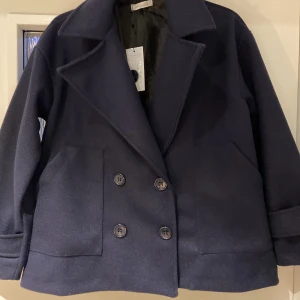 Kappa - Kappa från design by si mörkblå. Oanvänd och helt ny den har bra skick. Säljer den för att den var köpt i fel storlek. Pris kan diskuteras!