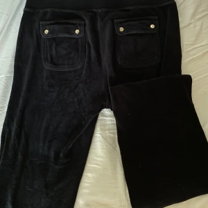 Vintage juicy byxor - Vintage lågmidjade juicy byxor, strlk L (sann till storlek, kan även passa M). Stretchig midja. Knapparna där bak är lite repiga och banden där fram är lite sletna! Fråga inte om bilder på tack!  Innerbenslängd: ca 75 