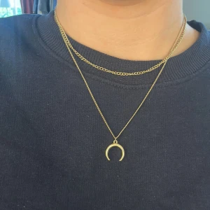 Halsband halvmåne - Guldfärgat ”dubbelhalsband” med halvmåne från H&M. Använd flertal gånger men har det senaste året bara legat. Längden är 37 cm på den innersta kedjan och den yttersta är ca 43 cm. Finns även förlängning som är 8 cm. Kan fraktas i kuvert för 15 kr. 