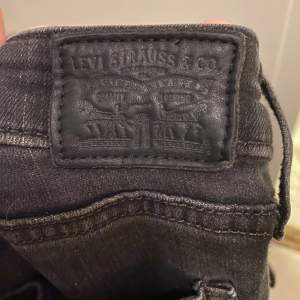 Tighta svarta jeans från Levis. Använda en gång men köpta second hand, därav något blekta i färgen. Inga defekter utöver det. Långa ben och något låg midja. 