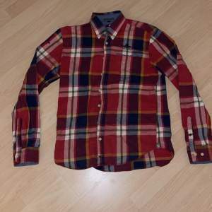 En fin ”New zealand” röd rutad skjorta, väldigt stabil kvalité. Detta är en tjockare skjorta och materialet är väldigt bekvämt.