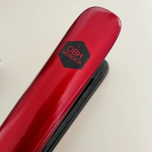 Plattång från OBH Nordica - En röd plattång som är knappt använd. Har 3 andra hemma och sträcker mig bara aldrig för denna. Det är 2 min uppvärmningstid. Keratinbehandlade flytande plattor i keramik ger ditt hår en skonsam  behandling och ett skinande resultat. Lång sladd (2.8m). 