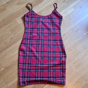 Miniklänning - Rödrutig snygg minidress i skönt material. Använd en gång. Det är strl m men jag skulle säga det är mer xs-s. Beror på hur kort man vill ha den.