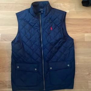 Polo Ralph Lauren väst  - Helt fräsch polo ralph lauren väst barbour. Använd ett fåtal gånger. Det är en XL ( 18-20 ), men passar mig som annars har stl  M/L. Pris kan diskuteras vid intresse!