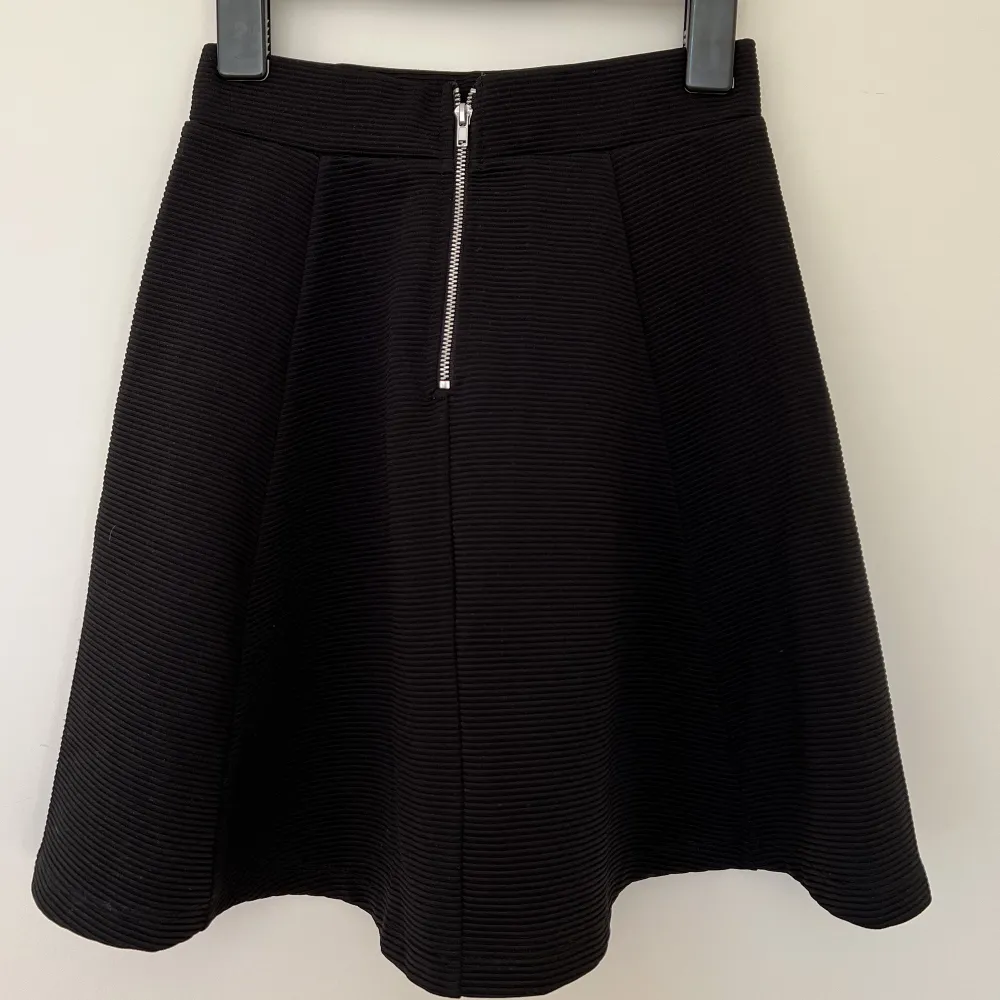 En svart kjol från H&M med en dragkedja där bak.. Kjolar.