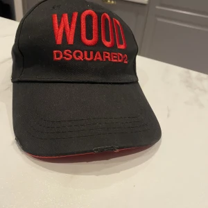 Dsquared2 keps - Dsquard2 keps mycket bra skick, det på skärmen är designen, alltså så är den inte trasig, det ska va så
