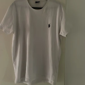 Polo raulph lauren tshirt  - En polo raulph lauren T-shirt i färgen vit, väldigt skön och fin tröja, skicket på tröjan är suverän, inga defekter överhuvudtaget, använd ett par gånger. Kontakta gärna mig vid fundering!👍