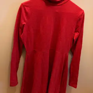 En helt oanvänd röd klänning från märket Boohoo. Vanligt rött tyg och är i storlek M/40. Har en hög halskrage. 
