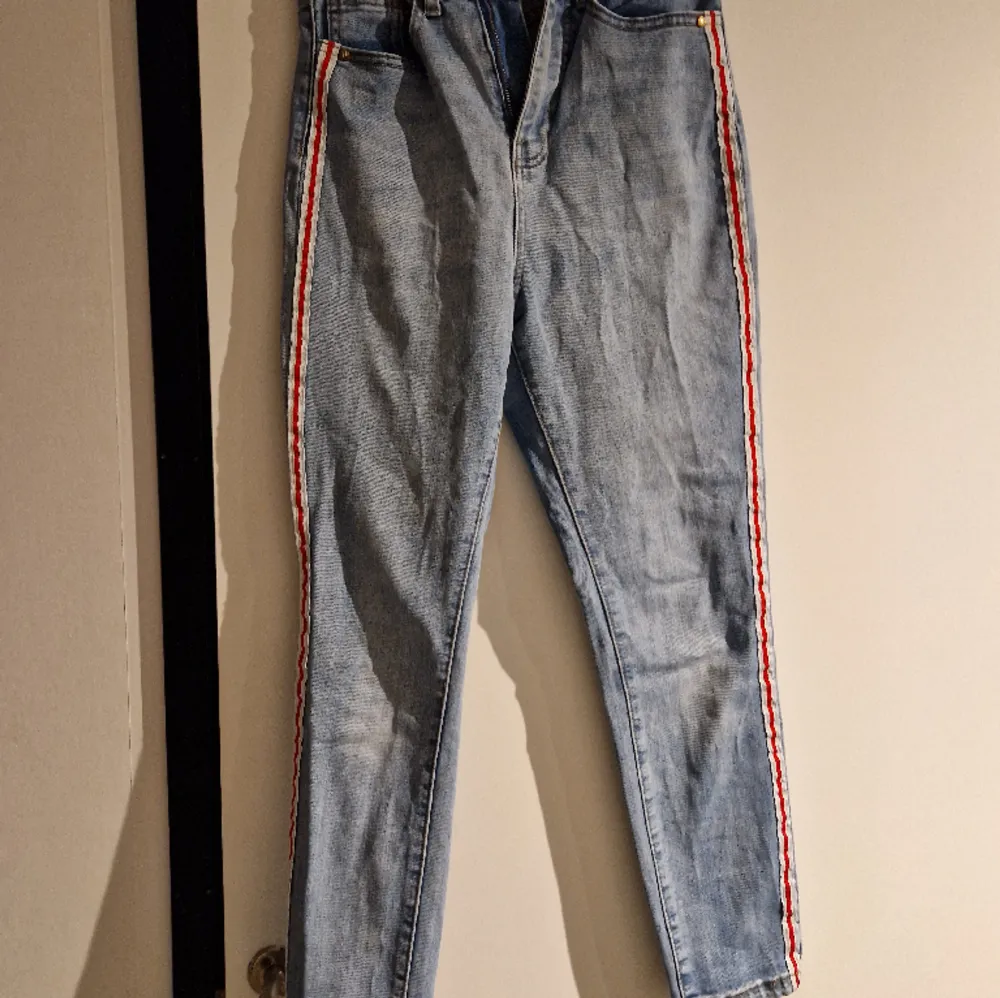 Jeans i tight modell med snygg detalj med randen på utsidan av benen . Jeans & Byxor.