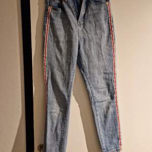 Jeans i tight modell med snygg detalj med randen på utsidan av benen 