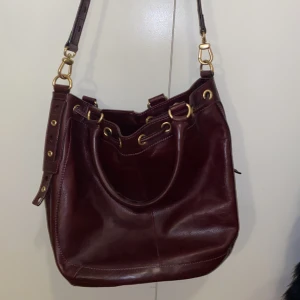 Manette lepore väska - En vinröd axelremsväska med gulddetaljer nyskick💗