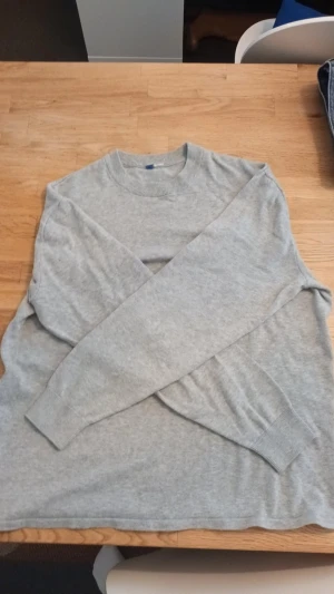 Grå stickad tröja - En grå stickad tröja i storlek l, vet ej mårke men om ni har frågor skriv!! 