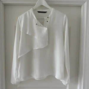 Blus  - Vit blus från Zara med fin drapering. Dolda tryckknappar. 