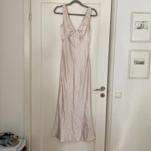 Helt ny balklänning - Helt oanvänd med prislappen kvar, ljusrosa/champagnefärgad långklänning. Djup i ryggen.