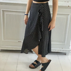 Söt prickig kjol - Fin kjol i omlottmodell med volanger och snyggt fall. Storlek 36.