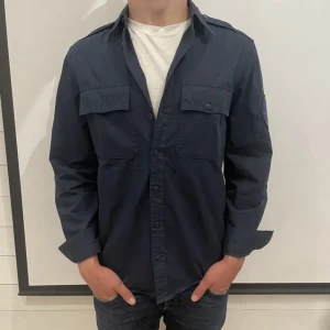 Zadig & volataire overshirt - Overshirt fran Zadig & Voltaire - Broderad logotyp pà vänster arm - Storlek : 38 motsvarar M - Overshirten r i väldigt fint skick och har inga defekter - Varat pris : 599 - Nypris: 2599-Modellen pä bilden är 180 CM och väger 75 kg