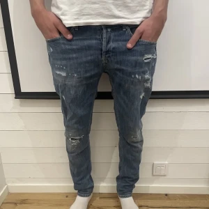 Dondup jeans - Jeans fran Dondup - Logotyp pa höger bakficka - Storlek: 38 - Passform - George - Jeansen är i bra skick utan defekter OBS slitningarna är fran början - Varat pris: 399 SEK - Nypris: 3399 SEK - Modellen pà bilden är 193 CM och väger 90 kg