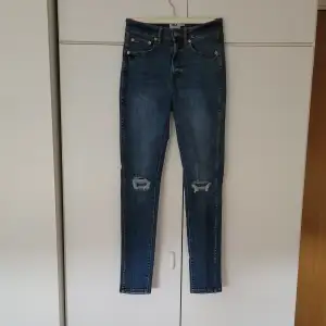 Blåa jeans från lager 157 i storlek S. Fickor både fram och bak. Dragkedja och knapp i fram. Högmidjade, skinnyjeans. 104 cm från midjan till benets slut. Innerbenslängden är 70 cm. 