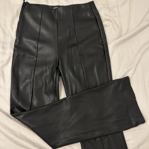 Skinnbyxor  - Högmidjade PU byxor i toppenskick. Märke Cindy.h (Paris). Strl 36. Byxorna har slits längst ner (se bild 3).