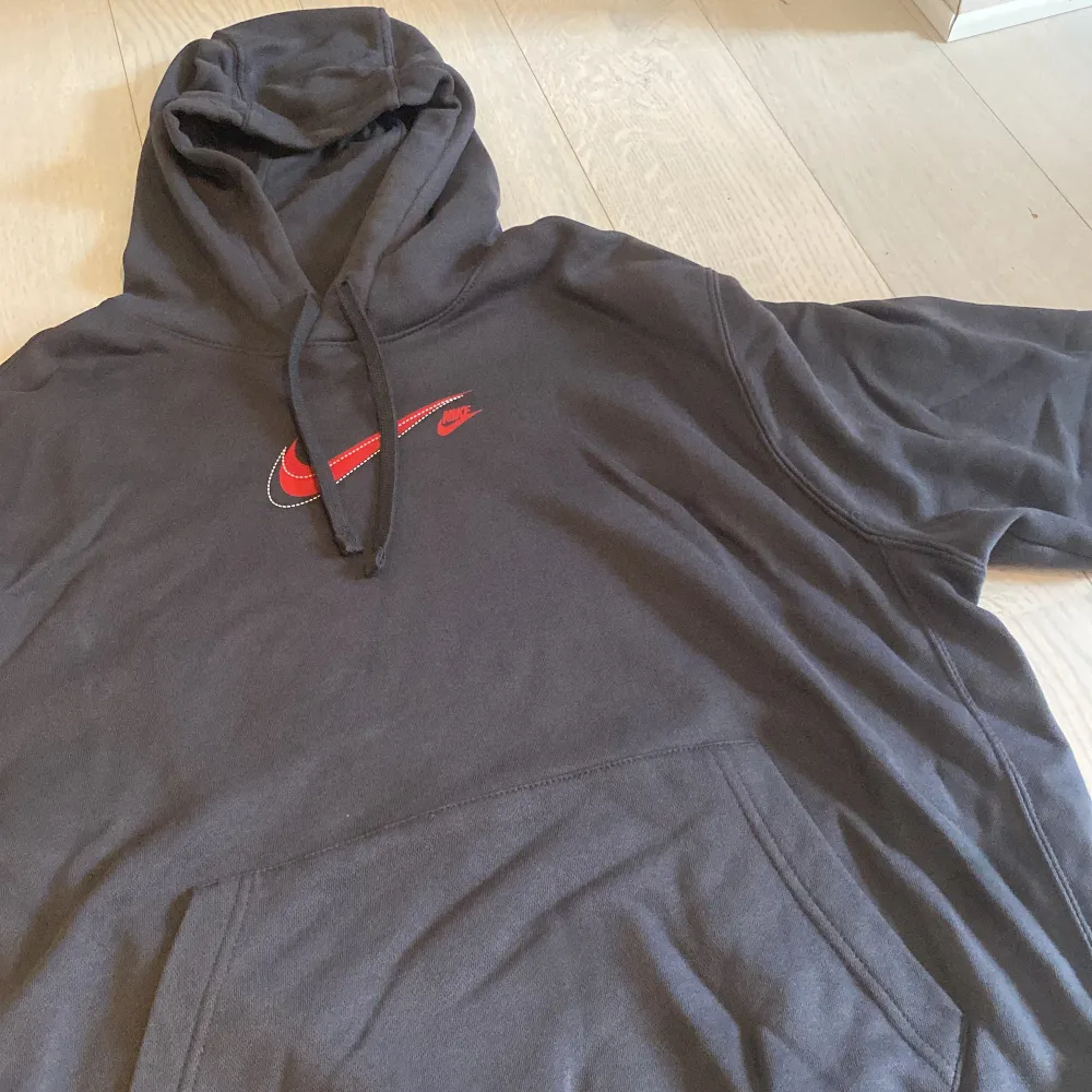 Grå Nike hoodie med röda detaljer. Använd 3 gånger så 9,5/10 skick. Köpt 2023 ifrån zalando. Nypris 600kr. . Hoodies.