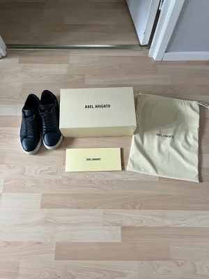 Axel arigato Clean 90 - Jag säljer mina Axel arigatos pga dom har blivit försmå, skorna är i bra skick och de med följer skolåda med mera. Skorna är använda ungefär ett halvår men som sagt inte sönder eller några märken. Skorna kan skickas men då står köparen för frakten