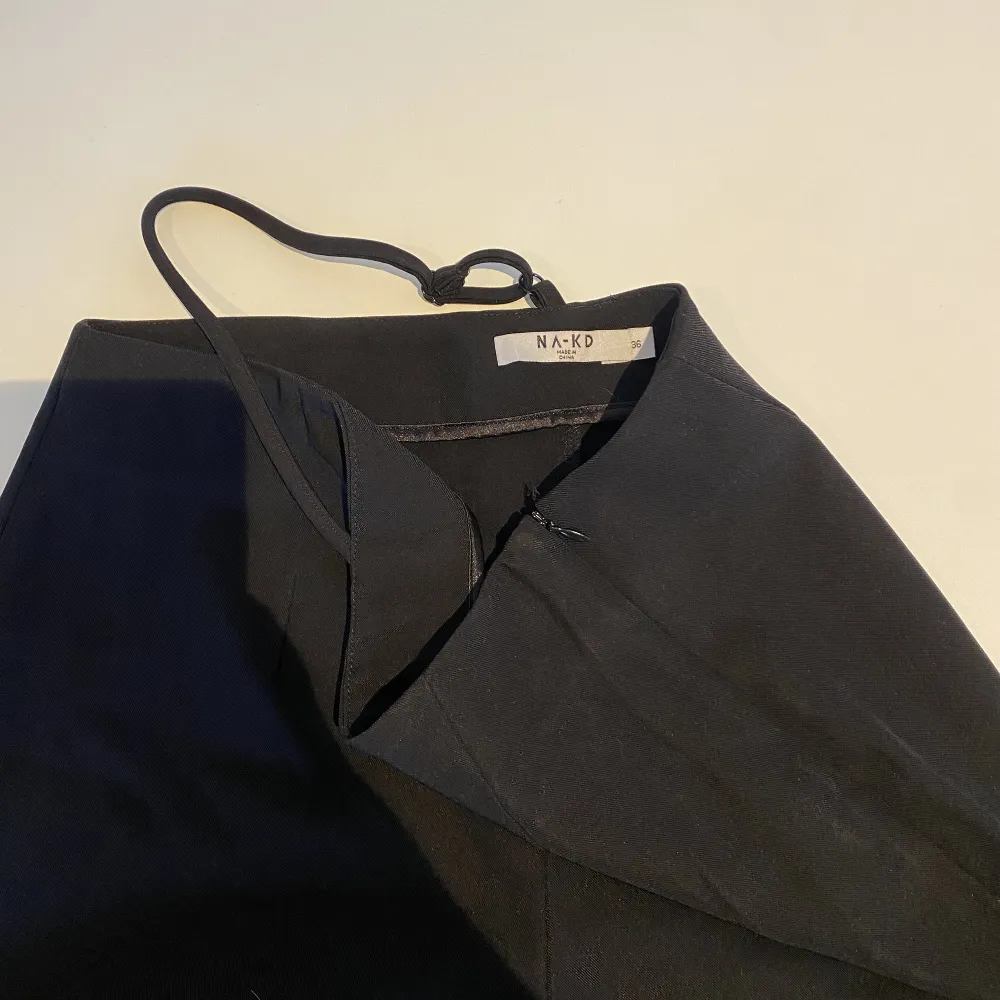 Svarta kostymbyxor med en justerbar remdetalj i midjan, raka ben och försluts med en dragkedja i sidan. Använda fåtal gånger.. Jeans & Byxor.