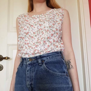 Blommig blus - Somrig blus med blommönster och små volanger framtill.