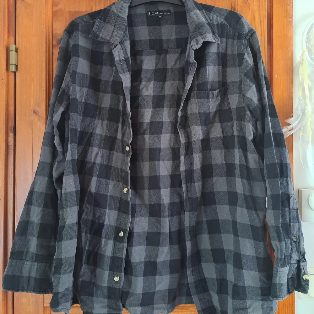 En grå/svart skjorta i storlek XL, tvättas innan den skickas. . Skjortor.