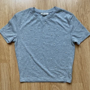 T-shirt  - T-shirt med små vita pärlor 
