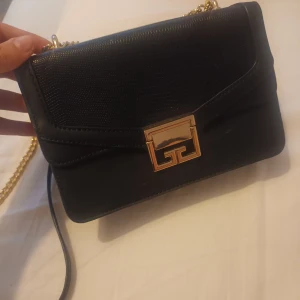 Svarta axelväska  - Säljer i bra skick jättefint svart liten axelväska med guld kedja,som köpte från Zalando före år. Köpare står för frakten