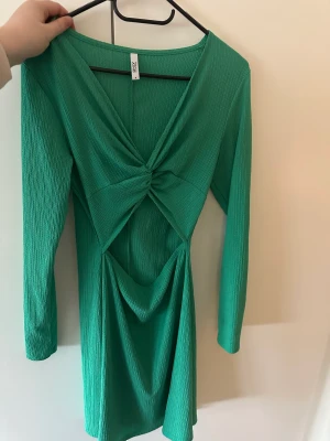 Grön klänning  - Jättefin somrig klänning med en öppning nedanför brösten. Endast använt en gång så i fint skick.