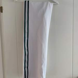 Vita byxor från Gina med grön/vit rand på sidorna. Nästan aldrig använda