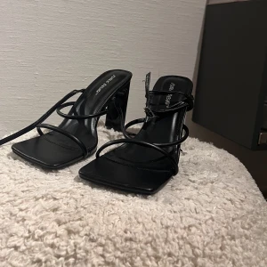 Klackskor  - Svarta klackskor med band runt fot och fotled I utmärkt skick då dem aldrig använts  Höjd på klacken är 8,5 cm 