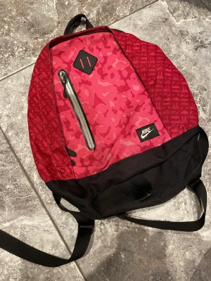 Nike rosa väska - En Nike rosa väska som har krånglig dragkedja. I använt skick med några fläckar. Jättefina fin färg, neon liknande.  Kika gärna på min andra annonser, säljer mycket:) Samfraktar gärna.