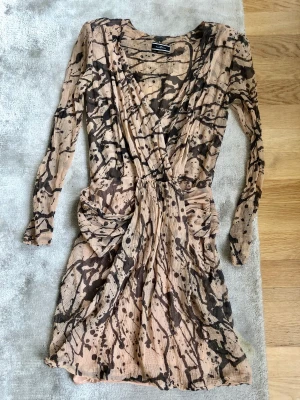 By Malene Birger, mönstrad klänning stl 36 - Klänning från by Malene Birger i mönstrat tyg med insydd underklänning och axelvaddar. Nypris ca 2300kr. Stl 36.  Ligger ute på flera ställen samtidigt. Se mina övriga annonser, då jag säljer liknande kläder och smycken.   Kan hämtas hos mig också.