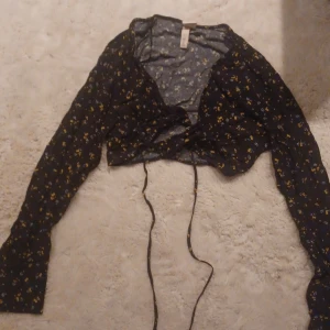Blus - Superfin Svart blommig knyt blus från hm, storlek 36,andvänd få gånger, säljs pga att den är för liten💗